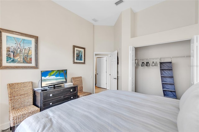 bedroom featuring a towering ceiling and a closet