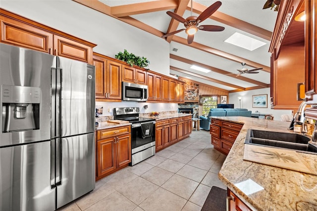 kitchen featuring light stone counters, stainless steel appliances, sink, and light tile patterned floors