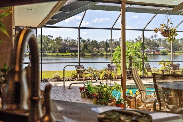 sunroom featuring a water view