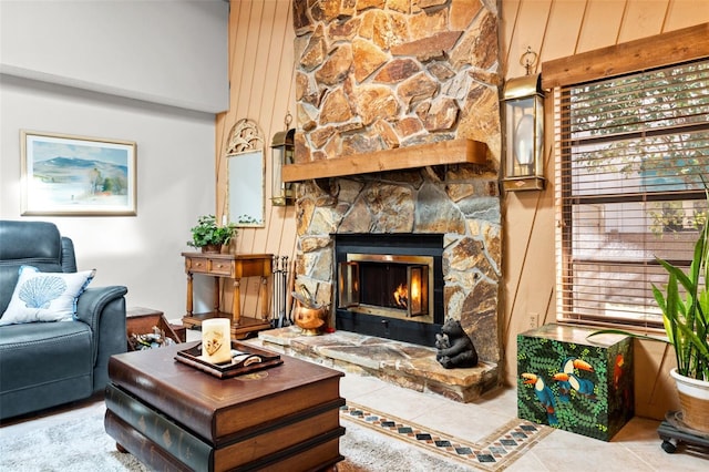 tiled living room with a stone fireplace