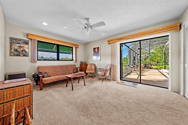 sitting room featuring ceiling fan, carpet, and a textured ceiling