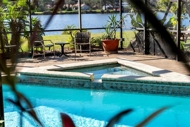 view of pool featuring an in ground hot tub, a water view, and glass enclosure