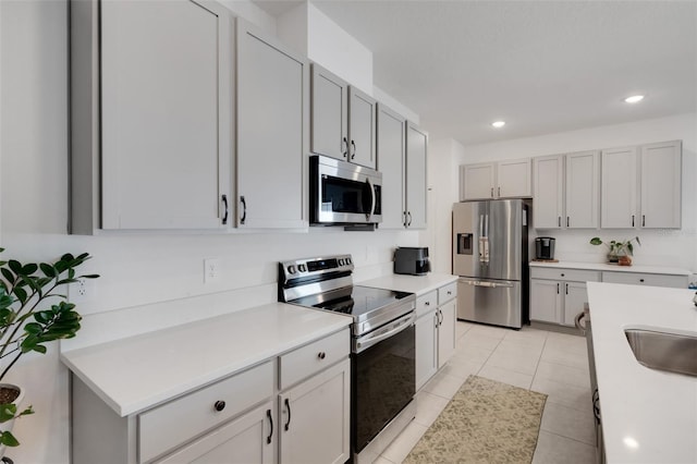 kitchen with light tile patterned floors, stainless steel appliances, and sink