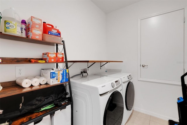 clothes washing area with washer and dryer and light tile patterned floors