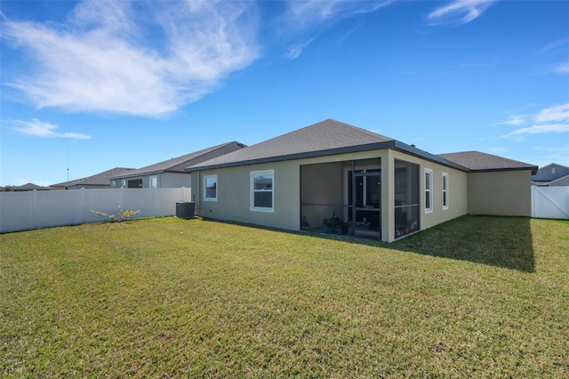 back of house featuring a sunroom, central AC unit, and a lawn