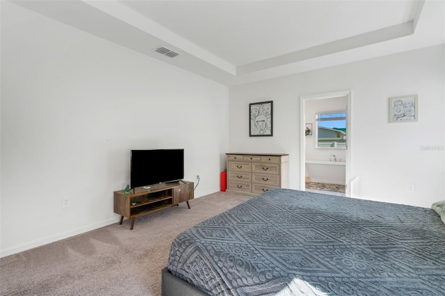 bedroom with carpet flooring and a raised ceiling