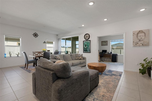 tiled living room featuring a wealth of natural light and a textured ceiling