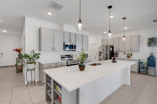 kitchen with a center island with sink, appliances with stainless steel finishes, sink, and gray cabinetry