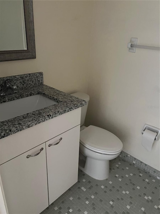 bathroom with vanity, tile patterned floors, and toilet