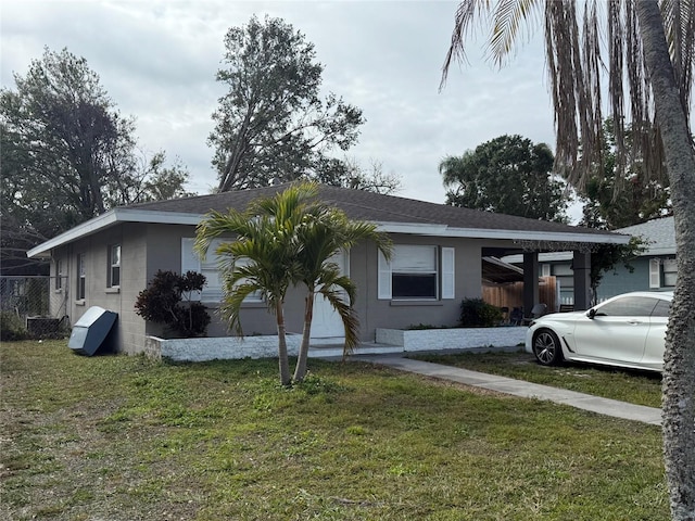 view of front of property featuring a front lawn and a carport