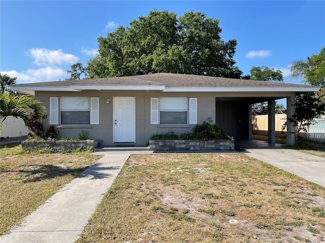 ranch-style home with a front yard and a carport