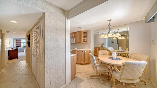 tiled dining area featuring an inviting chandelier