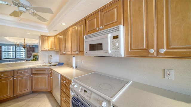 kitchen featuring sink, light tile patterned floors, a tray ceiling, crown molding, and white appliances