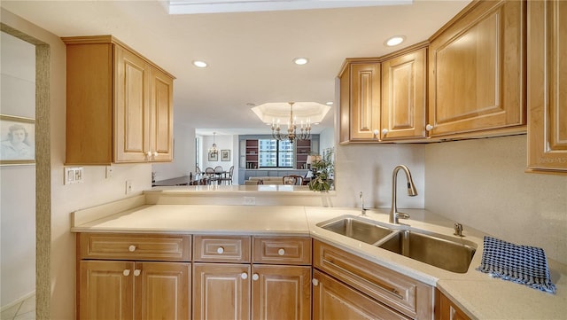 kitchen with pendant lighting, sink, kitchen peninsula, and a chandelier