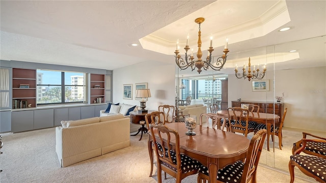 carpeted dining room with a notable chandelier, ornamental molding, and a raised ceiling