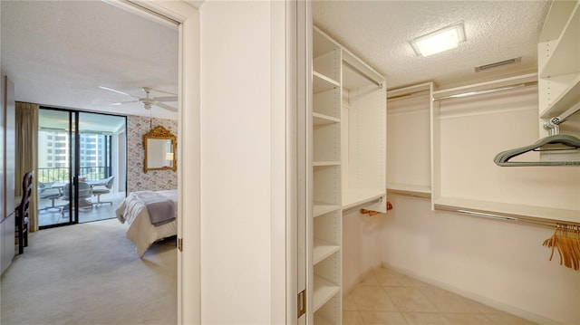 walk in closet with ceiling fan and light tile patterned flooring