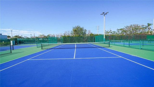 view of tennis court with basketball hoop