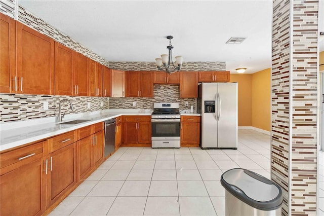 kitchen featuring a sink, backsplash, appliances with stainless steel finishes, and light countertops