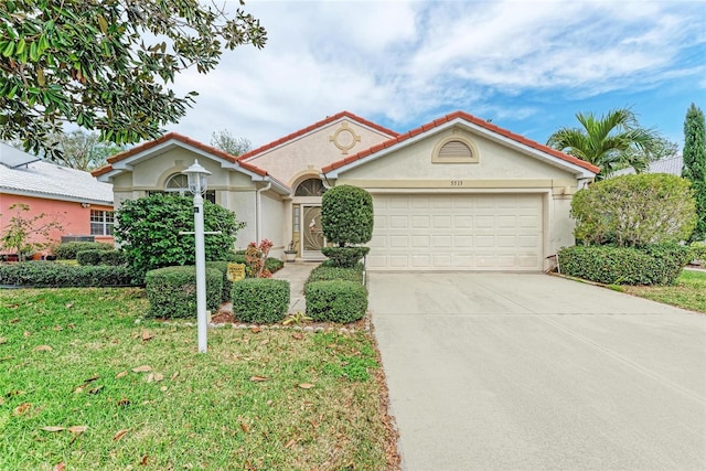 mediterranean / spanish home featuring a garage and a front lawn