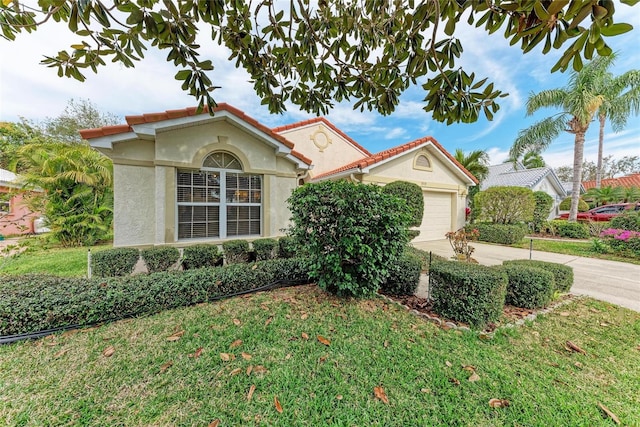 mediterranean / spanish-style house featuring a garage and a front yard