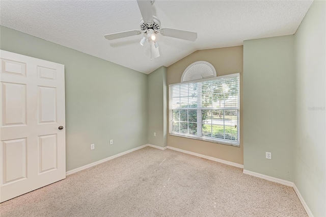 carpeted empty room with lofted ceiling, ceiling fan, and a textured ceiling