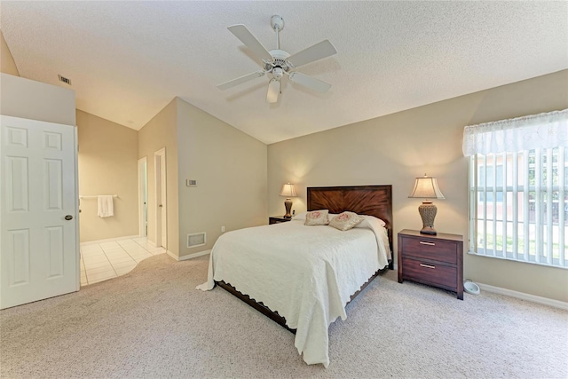 carpeted bedroom featuring vaulted ceiling, ceiling fan, and a textured ceiling