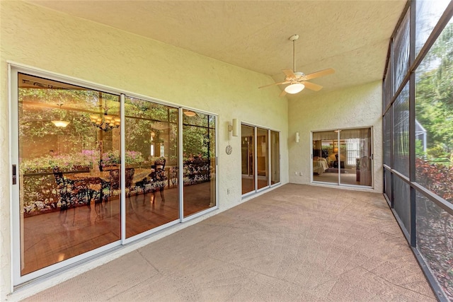 unfurnished sunroom with ceiling fan