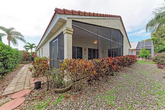 view of property exterior featuring glass enclosure