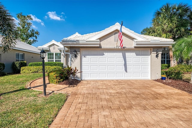 ranch-style house featuring a garage and a front lawn