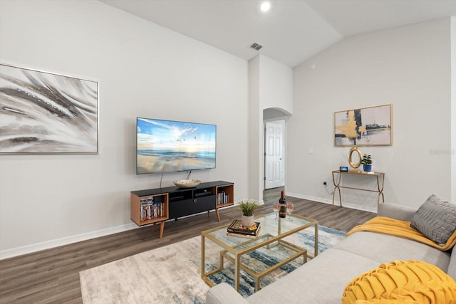 living room featuring dark wood-type flooring and high vaulted ceiling