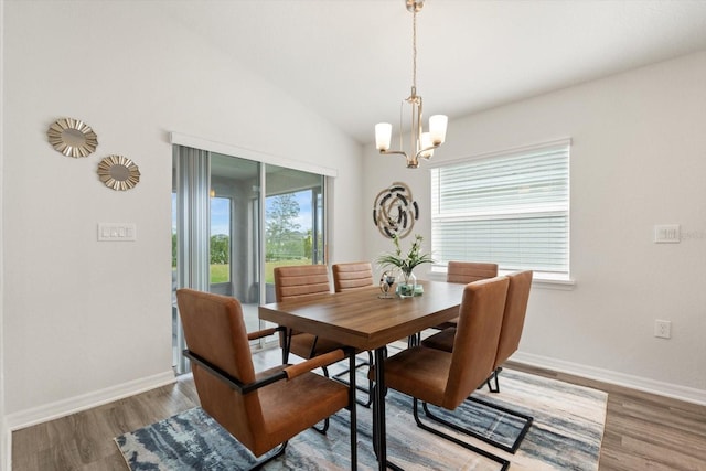 dining room featuring lofted ceiling, wood-type flooring, and a chandelier