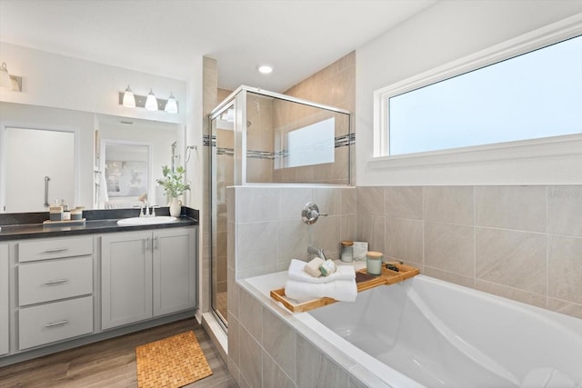 bathroom featuring vanity, plus walk in shower, and hardwood / wood-style floors