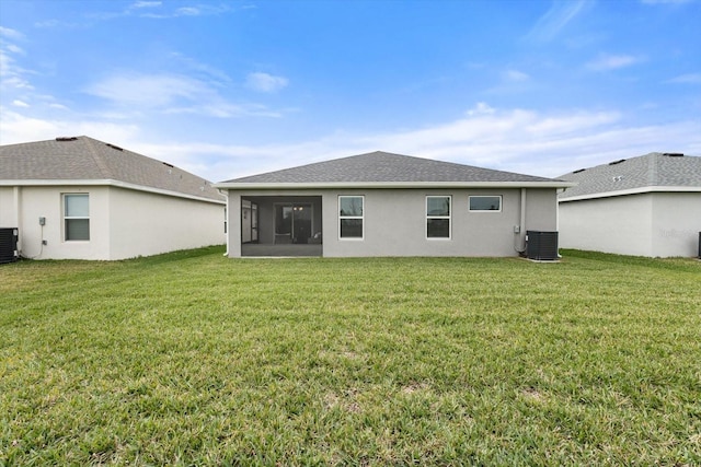 back of house featuring central AC unit, a lawn, and a sunroom