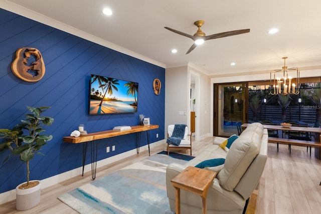 living room with crown molding, ceiling fan with notable chandelier, and light wood-type flooring