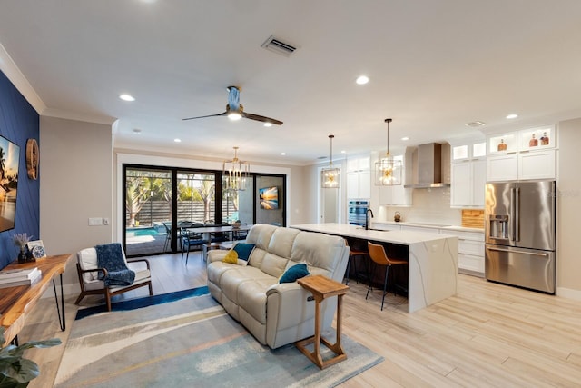 living room with crown molding, light hardwood / wood-style floors, and sink