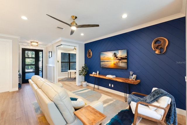 living room with crown molding, ceiling fan, and light hardwood / wood-style floors