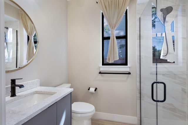 bathroom featuring vanity, toilet, a shower with door, and hardwood / wood-style floors