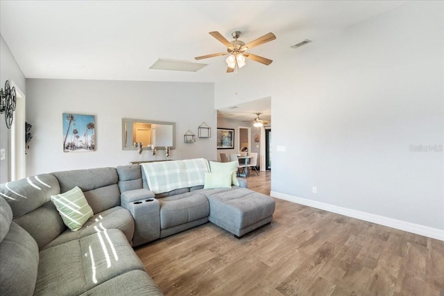 living room with vaulted ceiling, ceiling fan, and light hardwood / wood-style floors