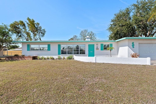 single story home with a garage and a front lawn