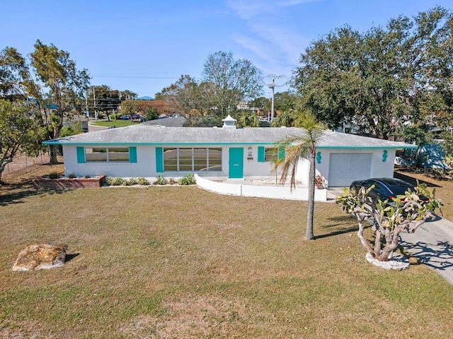 ranch-style home with stucco siding, a front lawn, and a garage