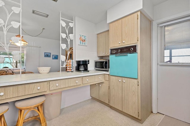 kitchen with wall oven and light brown cabinets