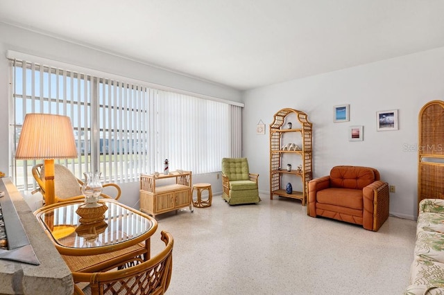 living area with speckled floor and baseboards