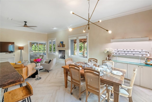 dining space featuring ceiling fan with notable chandelier, ornamental molding, and light parquet floors