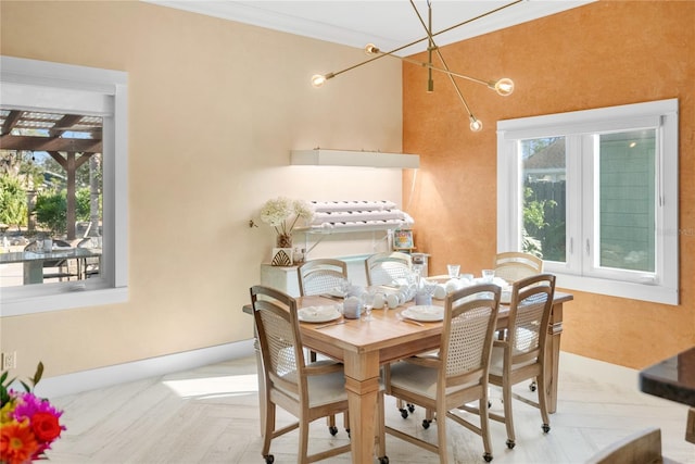 dining space featuring ornamental molding and light parquet flooring