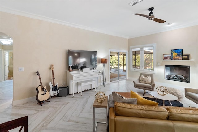 living room featuring ceiling fan, ornamental molding, and light parquet flooring