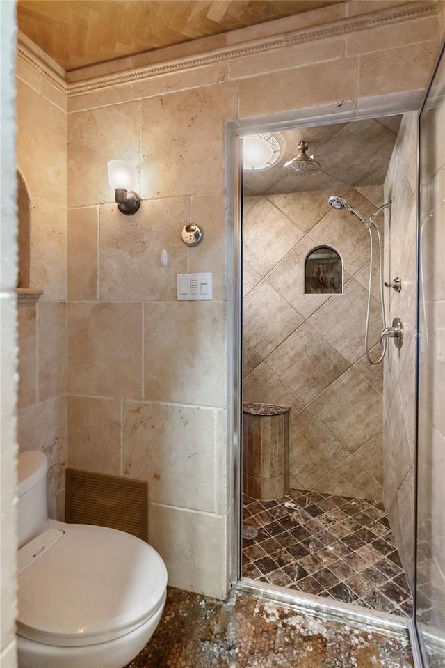 bathroom featuring tiled shower and toilet