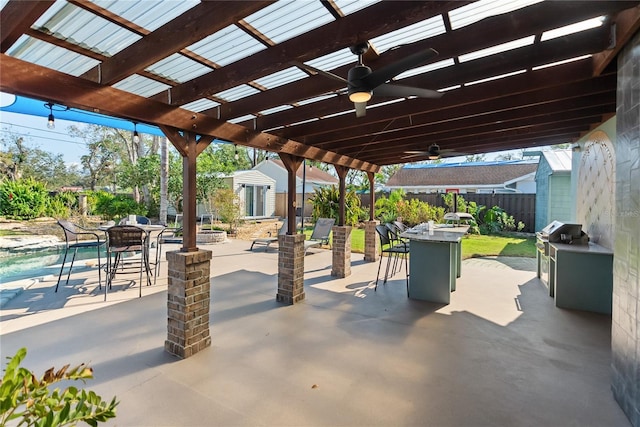 view of patio / terrace with a grill, ceiling fan, and a shed