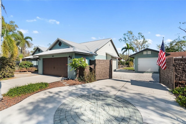 view of property exterior with a gate, fence, stucco siding, a garage, and metal roof