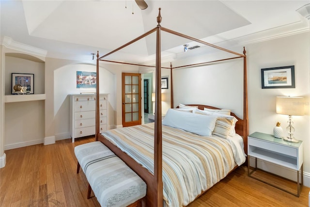 bedroom featuring crown molding, light hardwood / wood-style floors, and french doors