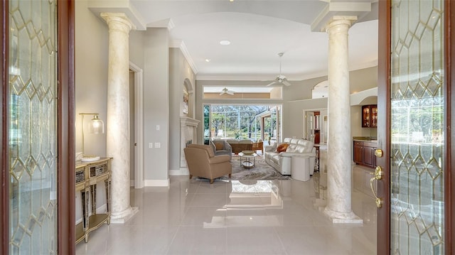 interior space with ornamental molding, decorative columns, and ceiling fan